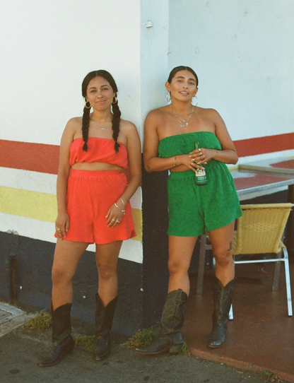 styled on film wearing matching terry tube tops and shorts in raspberry red and apple green styled with cowboy boots