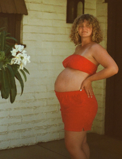 pregnant woman on film in palm springs wearing the terry tube top in raspberry red with the matching short in raspberry red