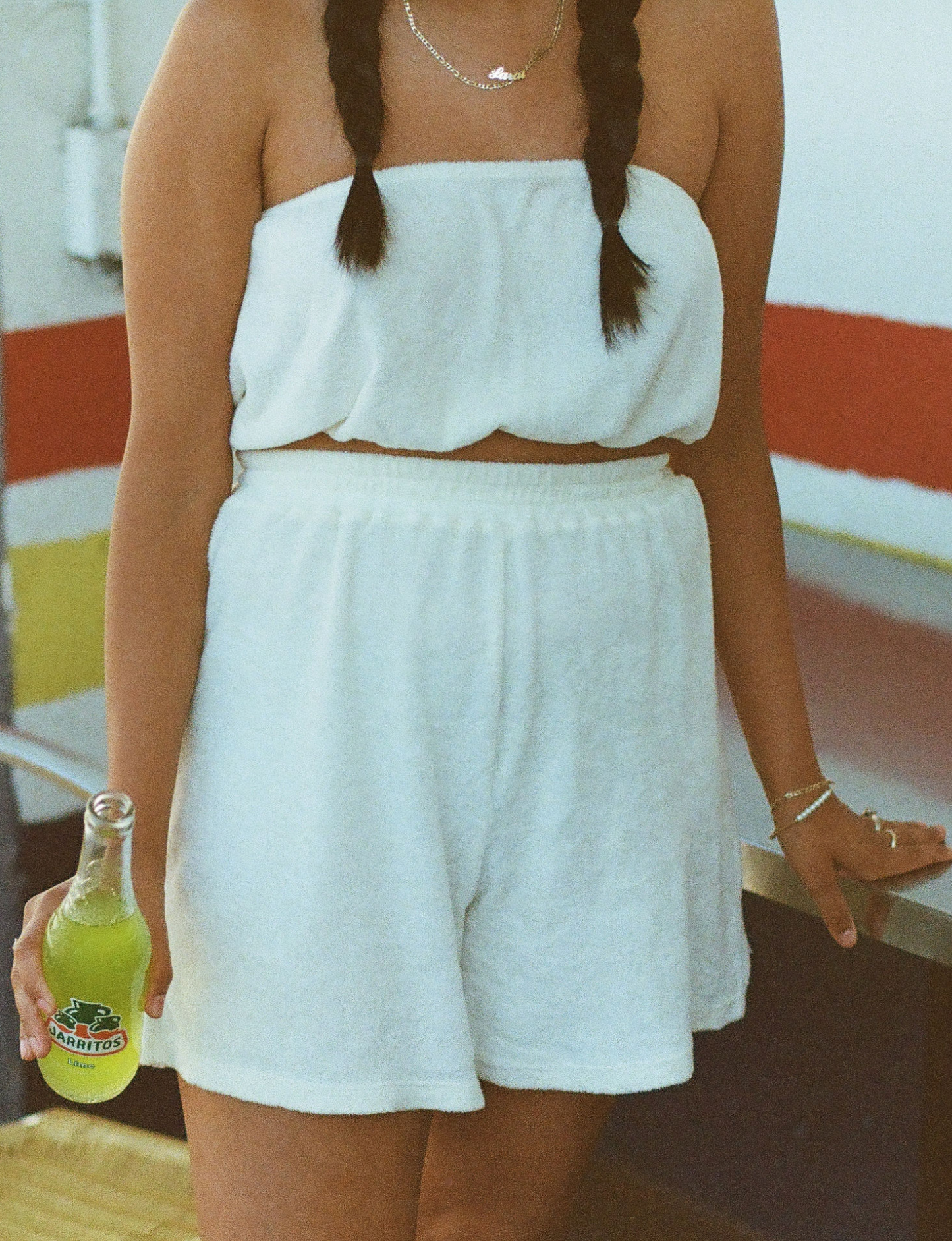 styled on film wearing the matching terry tube top and short in oat milk