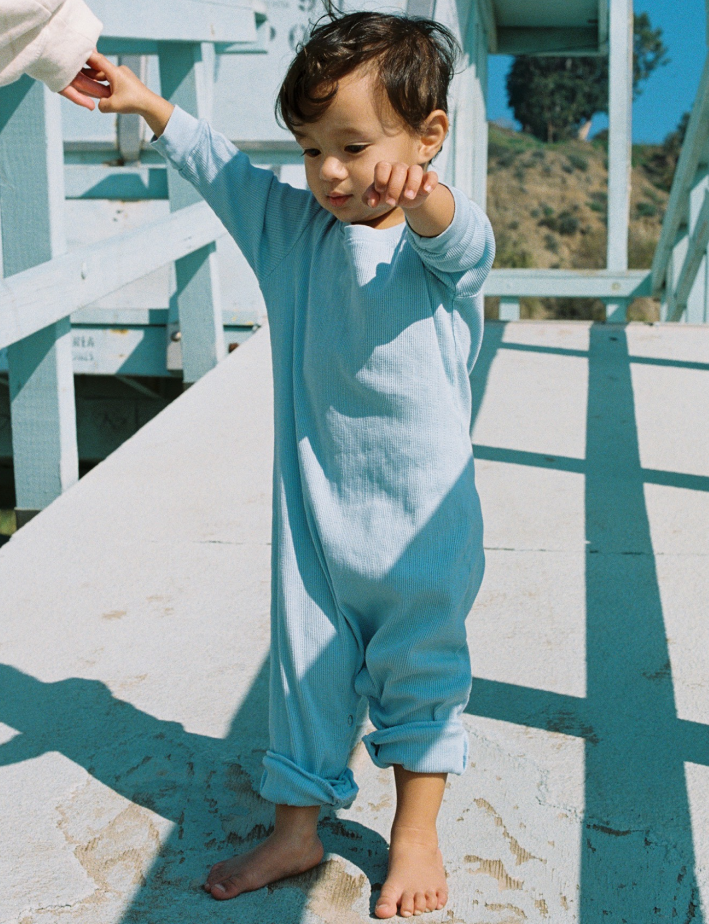 lifestyle sky blue pointelle onesie shot on film on the beach